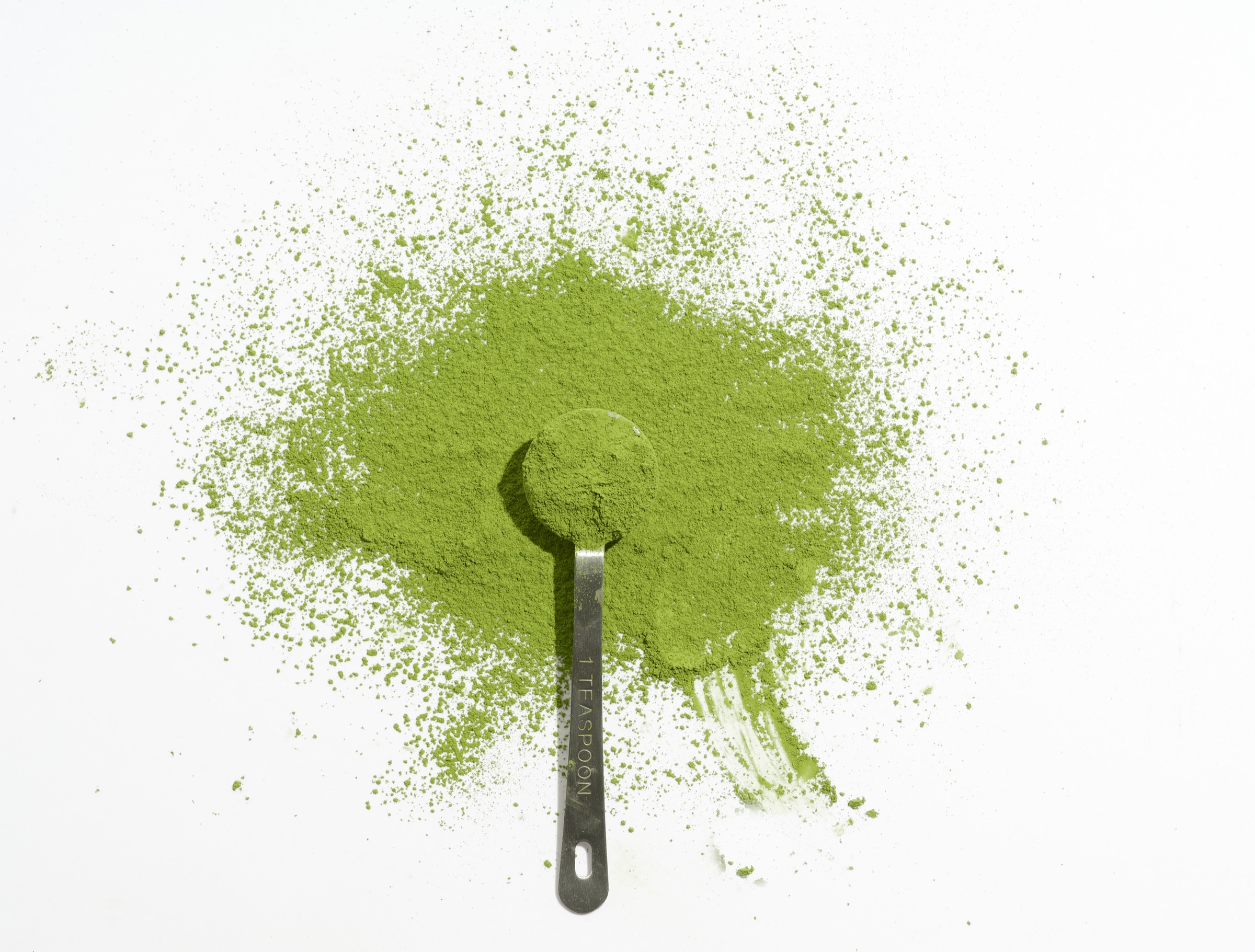 Vibrant green ceremonial matcha powder with measuring scoop